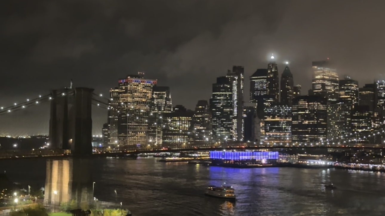 a photo of the east river,high rise buildings and a bridge from the pier.